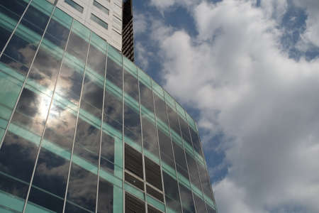 Yogyakarta, Indonesia, Sep 29, 2021. Modern building with glass facade and dramatic sky in the hot sun.のeditorial素材