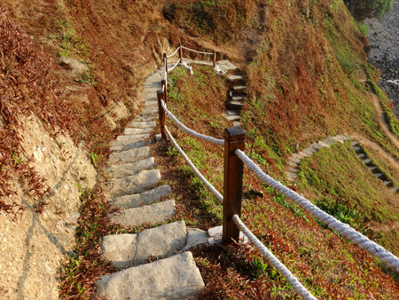 Stairs descending with simple handrail, on the hillside.