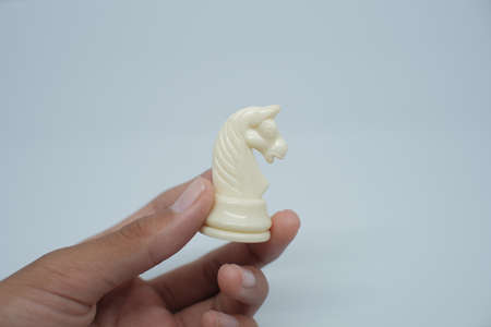 Someone's hand was holding a Knight chess piece. In the game of chess, horses or Knight have a unique and deadly move, namely the L move.の写真素材
