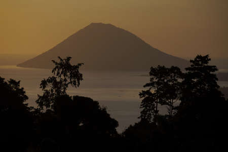 Manado Tua island in a tropical tree silhouette framing, North Sulawesi, Indonesia.の写真素材