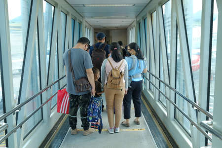 Bangka Belitung, Indonesia, Dec 21, 2021. Passengers pass through the garbarata or trunk ladder for boarding to the aircraft cabin.のeditorial素材