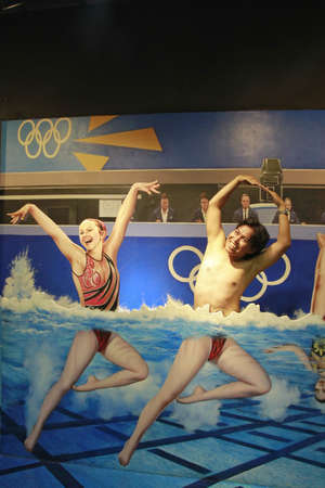 Singapore, Feb 25, 2015. Tourists pose with wallpapers of synchronized swimming athletes at Madame Tussauds Museum.のeditorial素材