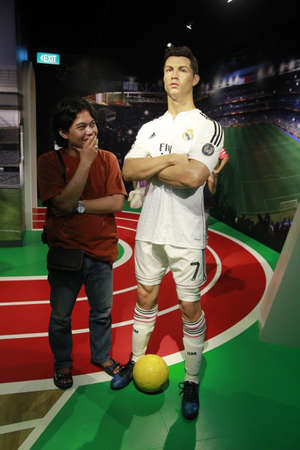 Singapore, Feb 25, 2015. Tourists pose with a wax statue of football legend Christiano Ronaldo at Madame Tussauds Museum.のeditorial素材