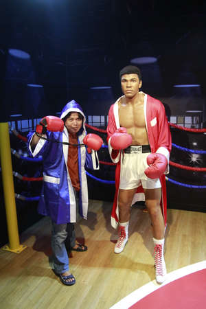 Singapore, Feb 25, 2015. Visitors pose with a wax statue of world-class boxer Muhammad Ali at Madame Tussauds Museum.のeditorial素材