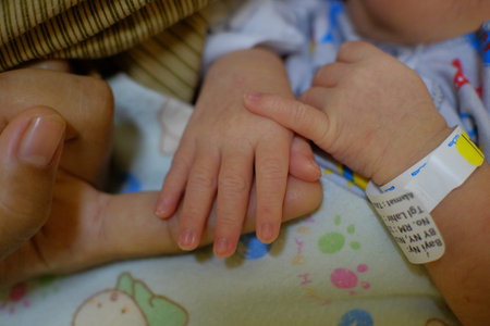 Klaten, Indonesia, Jan 9, 2022. The tiny fingers of a newborn baby are shown by someone's adult...