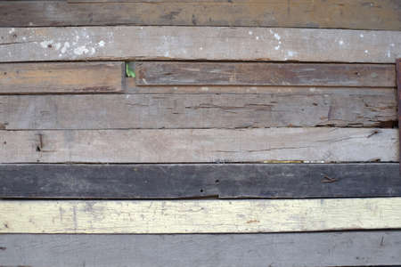 The arrangement of waste wood boards into one side of the wall of a simple building.の写真素材