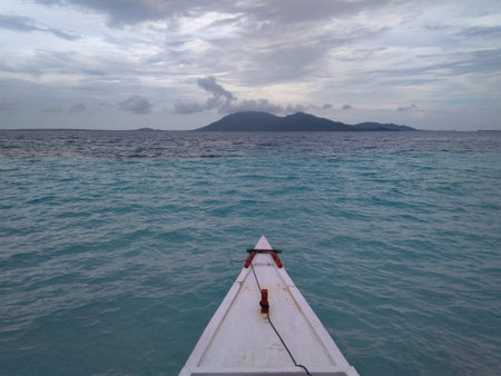 The tip of the traditional boat deck is conical in shape, crossing the calm and turquoise sea.