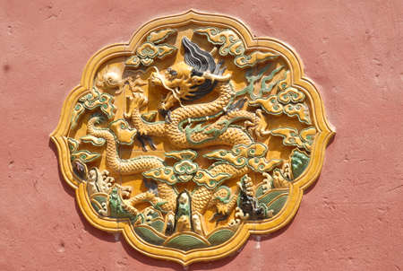 Classic decorative ornament on the wall with the main figure of a dragon, a mythological animal in Chinese culture.の写真素材