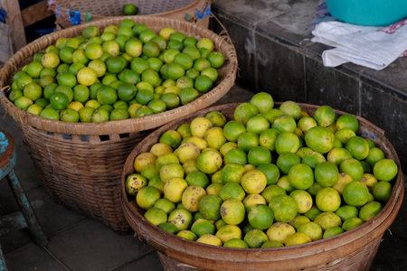 Pile of citrus fruits in a basket at a traditional market stall.の写真素材