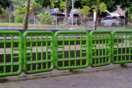 The iron fence painted green also functions as a gate that can be shifted to open and close.の写真素材