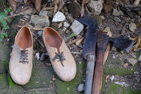 A pair of low-soled shoes and a sharp weapon for gardening tools.の写真素材