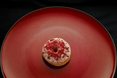 Donuts with sugar topping on a red plateの写真素材