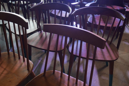 Antique chairs are arranged irregularly with lighting from behind.の写真素材