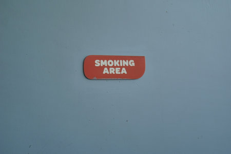 "Smoking Area" sign posted on the wallの写真素材