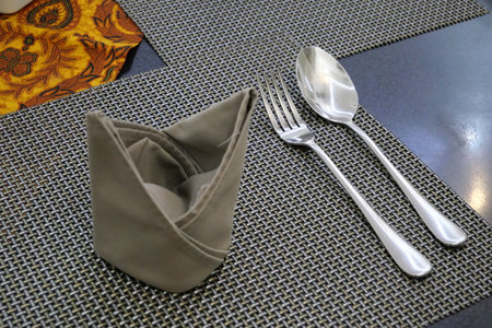 Cutlery and napkin prepared on a table in a restaurant.の写真素材
