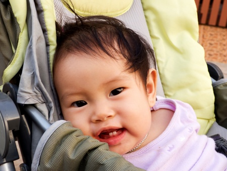 Smiling baby girl  in the strollerの写真素材