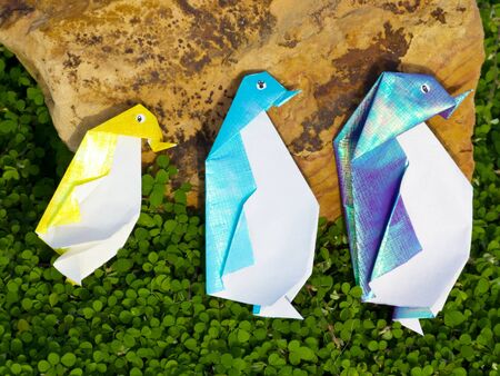 Penguin Origami family are walking along the green plantの写真素材