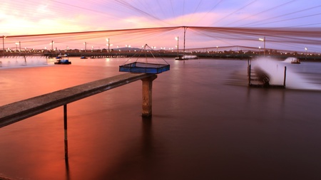 In evening sunset time at shrimps pond paddle wheel aerator are runningの写真素材
