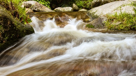Waterfalls are streams of clear water flowing through rocks large cascades down. A small pool to swim.の写真素材