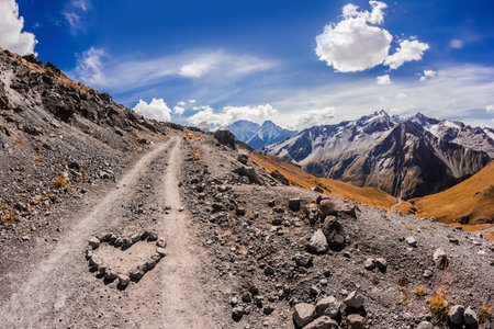 The main Caucasian ridge from mount Elbrus with a heart made of stones in the foreground,