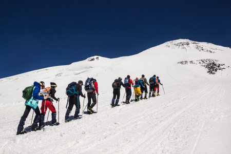 Russia, Elbrus - JULY 29, 2018: a Group of climbers lined up one after another go to the top of the mountain.every year thousands of tourists go to the mountainsのeditorial素材