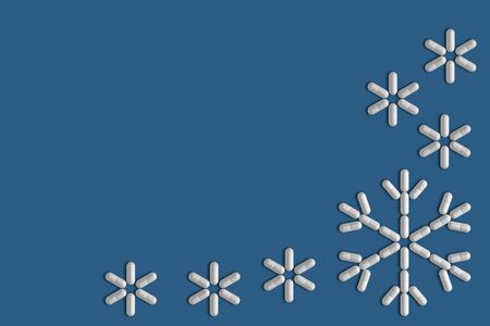 Silhouettes of snowflakes lined with pills on a blue uniform background 3d illustration,の写真素材