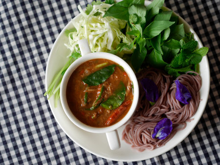 traditional thai noodle - Khanom jeen nam ya pa and vegetable noodle with herb on polka dot tableclothの写真素材