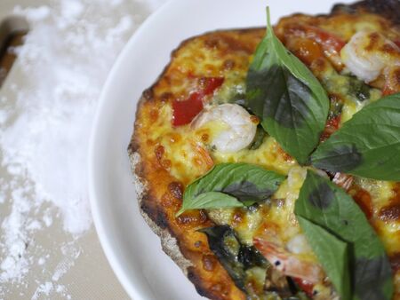 homemade pizza - rustic pizza, mozzarella cheese and shrimp with basil leavesの写真素材
