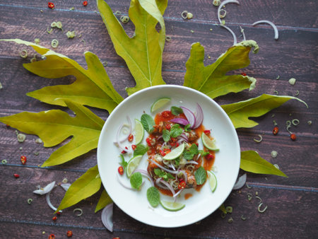Thai Food Style - Spicy fish Canned Sardines Salad on papaya leaf mixed with herb and lemonade, copy spaceの写真素材