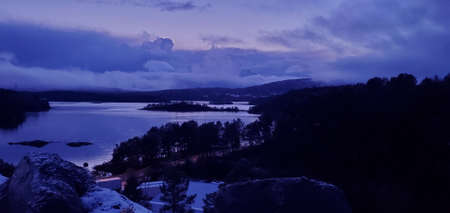 beautiful scenery of norwegian mountains, sea bay and cloudy evening skyの写真素材