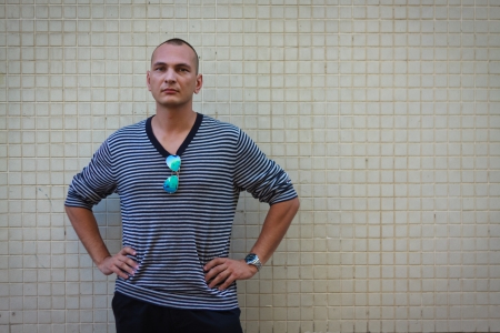 Portratit of handsome man in stripped sweater over beige wallのeditorial素材