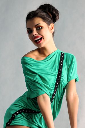 smiling girl posing in a green dress with glassesの写真素材