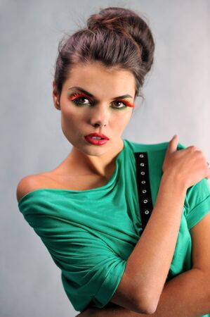 smiling girl posing in a green dress with glassesの写真素材