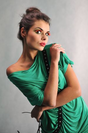 smiling girl posing in a green dress with glassesの写真素材