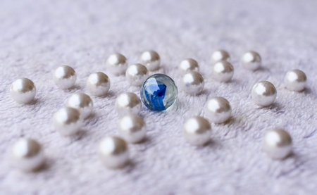 many white pearl and big crystal glass ball on white fur surface.leadership concept background.の写真素材