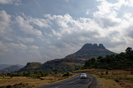 White car on empty mountain road  at Malshej Ghat District Pune State Maharashtra India January 26 2015の写真素材