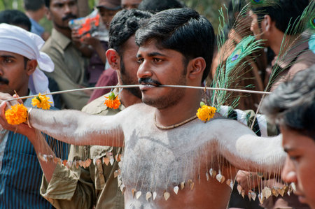 Man piercing spikes through cheeks discharging vow in Thaipusam Festival in state Kerala India 01 30...
