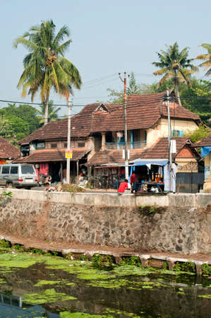 Traditional tiled roof houses and shops on the bank of canal at Alappuzha state Kerala India 02 02 2010のeditorial素材