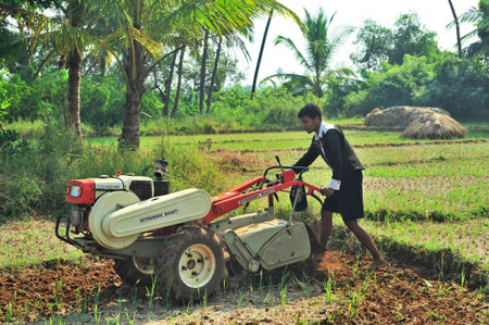 Farmer ploughing field with the help of power tiller at village Achara district Sindhudurga state Maharashtra India 11 07 2011のeditorial素材