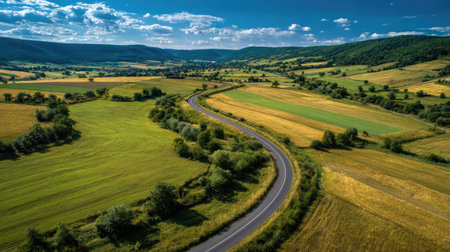 A photograph of Central European countryside with farmland with winding road, wild countryside...