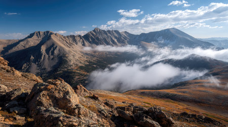 A photograph of Rocky Mountains wilderness 47 with rocky mountain peaks above clouds, rocky alpine...