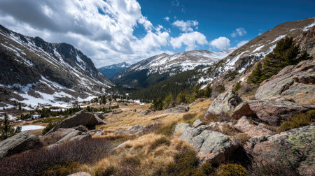 A photograph of Rocky Mountains wilderness with rocky mountain ridge overlooking valley, scattered alpine boulders, rocky mountain spring thaw, ultra realistic landscape photography, wide angle lens, natural colors, clean composition, no peopleの写真素材