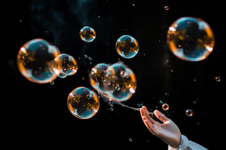 Hand reaches for soap bubbles on black background, close up. AI generated.の素材