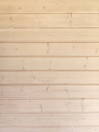 The smooth wooden wall features horizontal planks arranged neatly, exhibiting a light color and subtle texture. This setting creates a warm and inviting atmosphere within the room.の写真素材