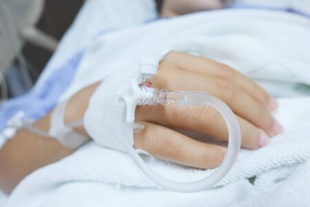 focusâonâ theâ handâ ofâ aâ patientâ inâ hospitalâ ward.â closeupâ ofâ aâ womanâ patientâ inâ hospitalâ withâ salineâ intravenousâ(iv)âの写真素材