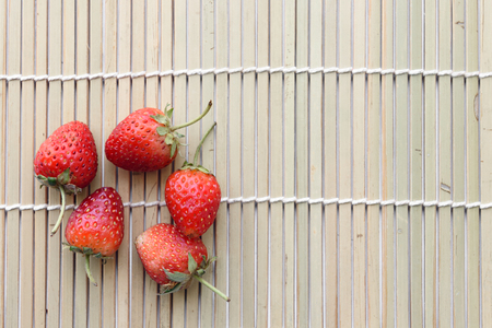 The pile of fresh strawberry put on the wooden trayの写真素材