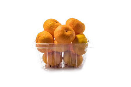 The pile of fresh oranges in the plastic basket isolated on white backgroundの写真素材