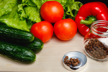 Fresh vegetables on the table: red pepper, lettuce, cucumber, tomatoes, sweet pepper peas. Cutting boardの写真素材