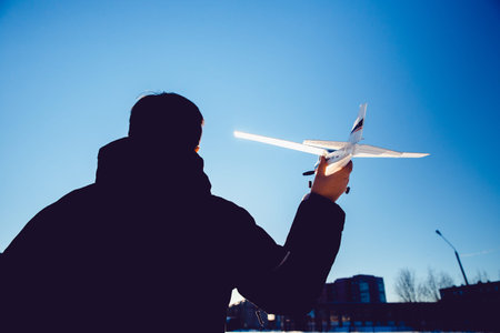plane is on the radio control, the guy is holding the plane in his hand at sunset. Run the model...