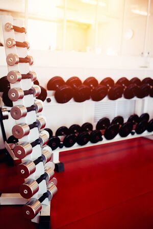 Sports equipment dumbbell rests in a row.  hign contrast and monochrome color toneの写真素材
